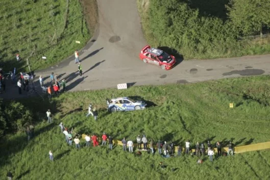 Gigi Galli's Mitsubishi passes the stricken Ford of Sola