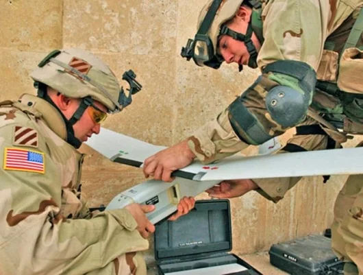 Cpl. Christopher Chladny, an unmanned aerial vehicle (UAV) pilot, and Pfc. Michael Compton, assemble the Raven UAV and prepare for a surveillance flight near Tikrit, Iraq