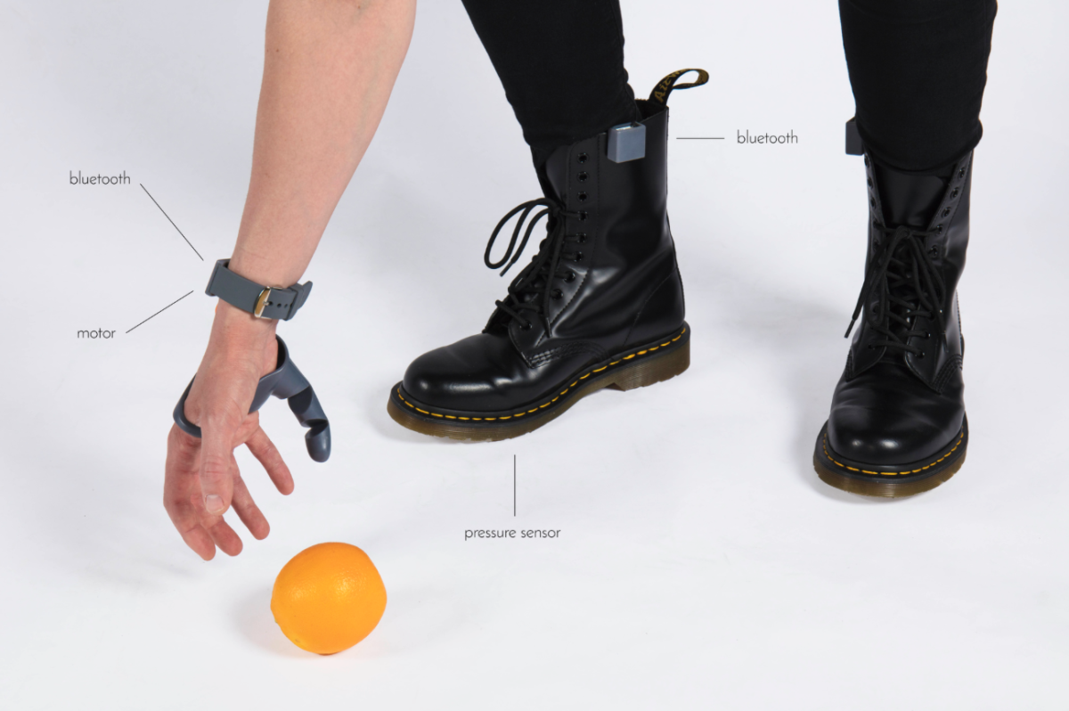 Sensors under the feet control the thumb's movements via Bluetooth