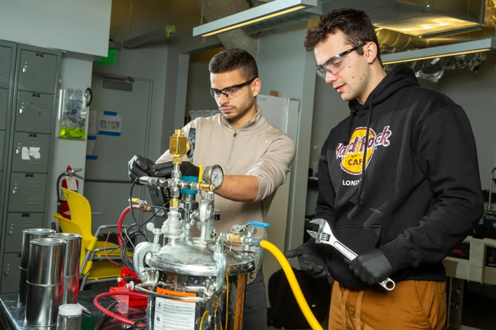 MIT researchers Aly Kombargi (left) and Niko Tsakiris (right) with their new hydrogen reactor