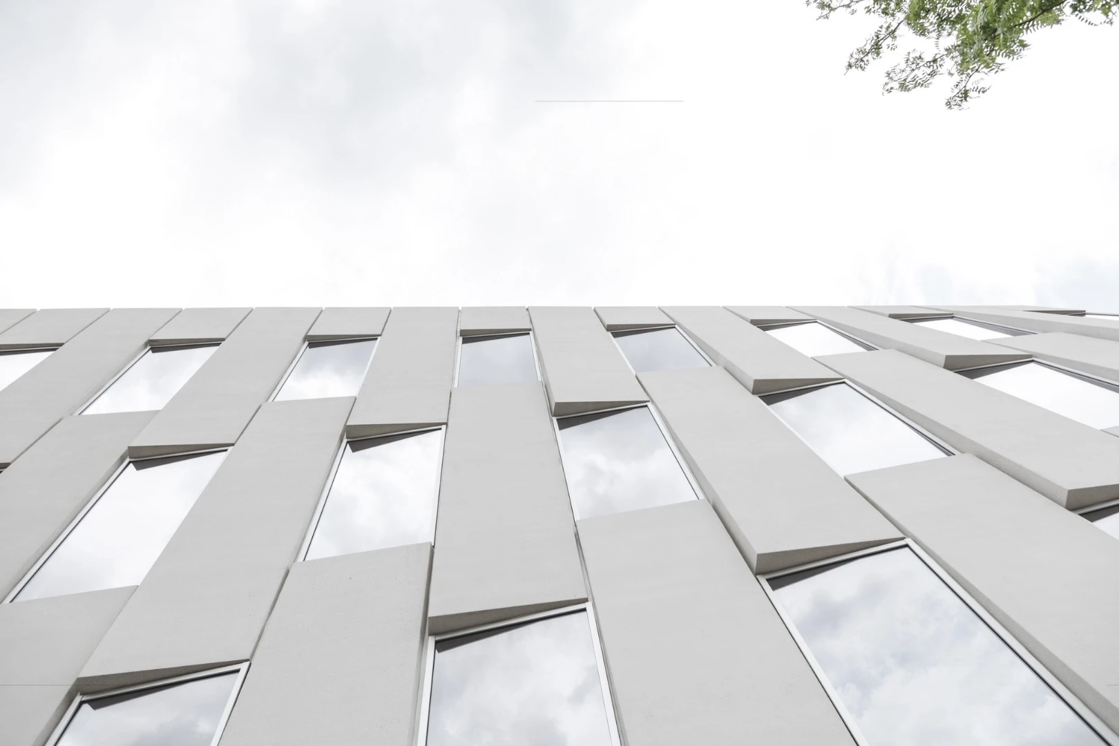 The facade of 1200 Intrepid Avenue sees the precast concrete panels stacked in a basket-weave pattern, tilting outwards as they rise