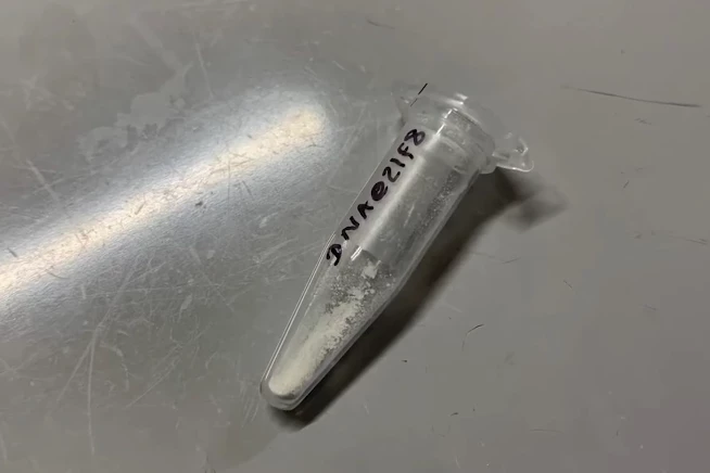 A vial of ZIF-8 microparticles