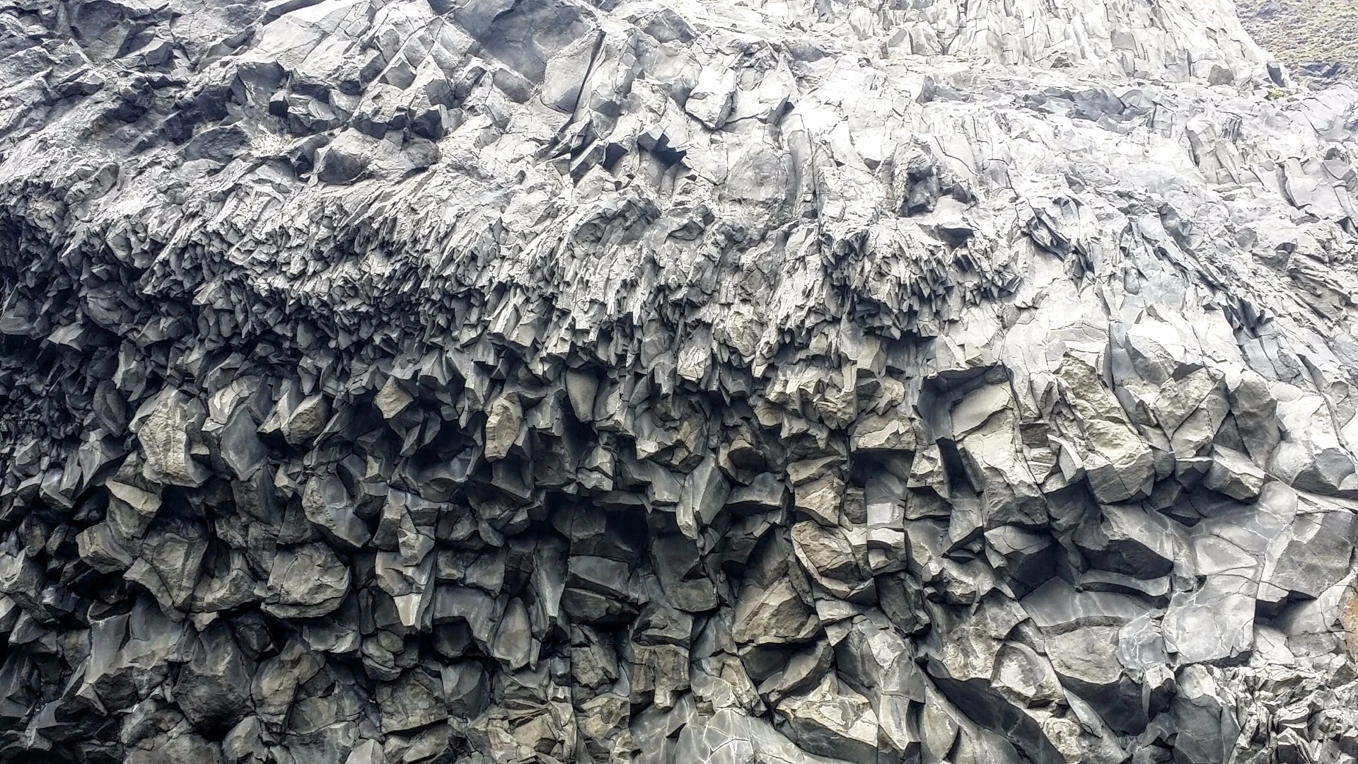 When lava flows hit a turbulent water source, such as the ocean at Reynisfjara, the resulting pattern can be slightly more erratic, as this close-up of a cave entrance on the beach shows.
