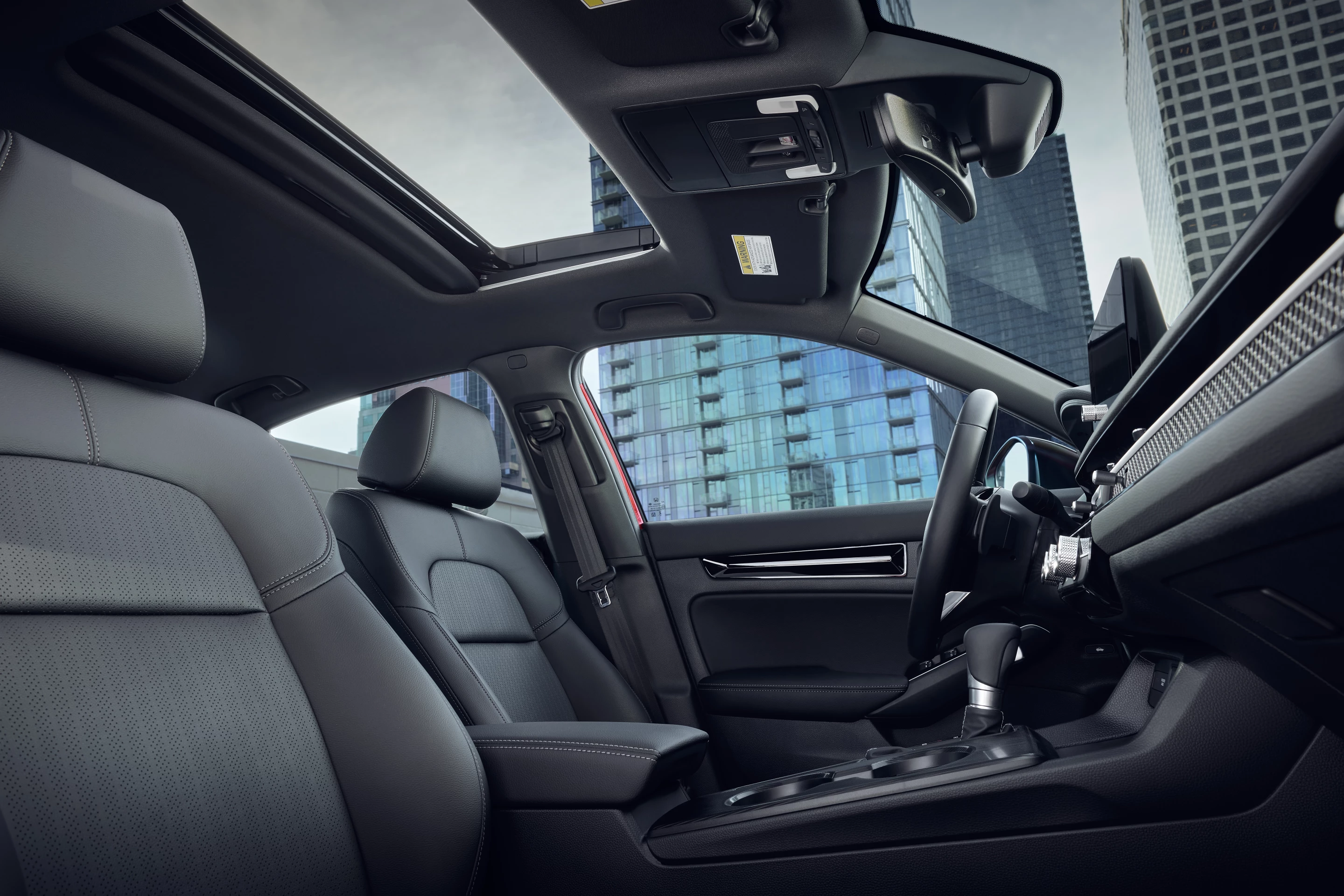 The interior of the 2025 Honda Civic Hybrid has comfortable front seating and storage