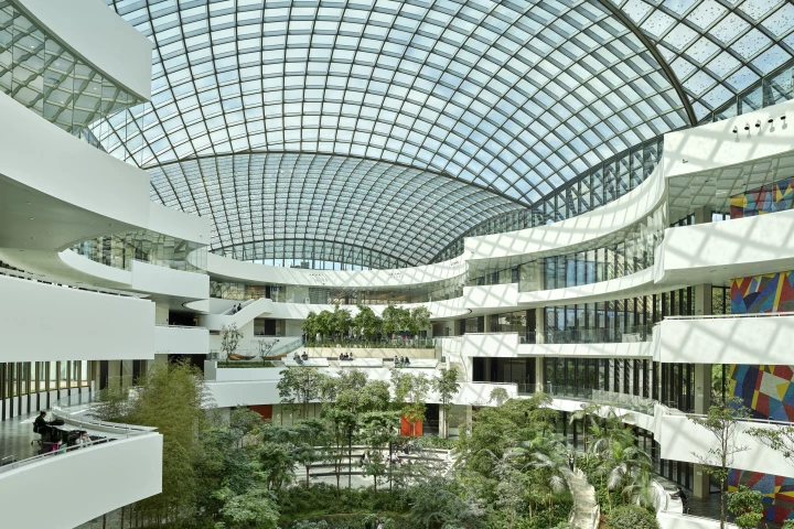 The Albert Einstein Education and Research Center's glass roof encloses a lush green atrium space