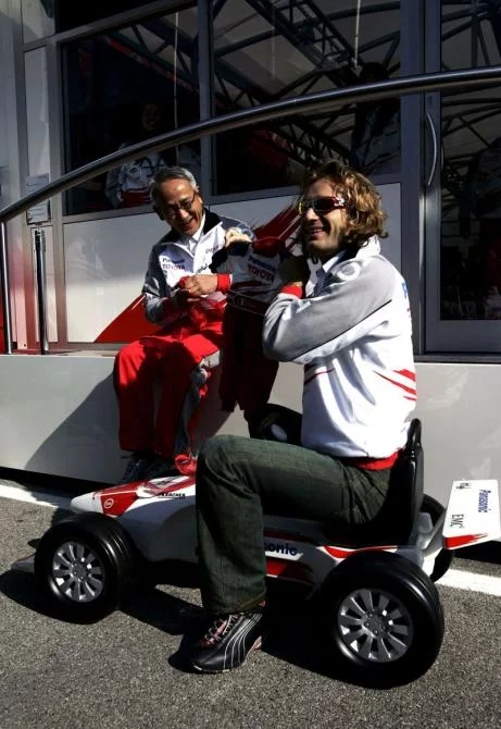 Toyota Team Principal Tsutomu Tomita presents Jarno Trulli with team's present for the birth of his son