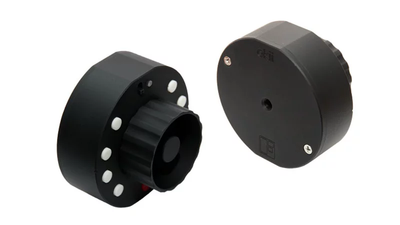 The Okii Systems USB Follow Focus features a rugged aluminum housing with a central focus knob and a threaded mount on the back