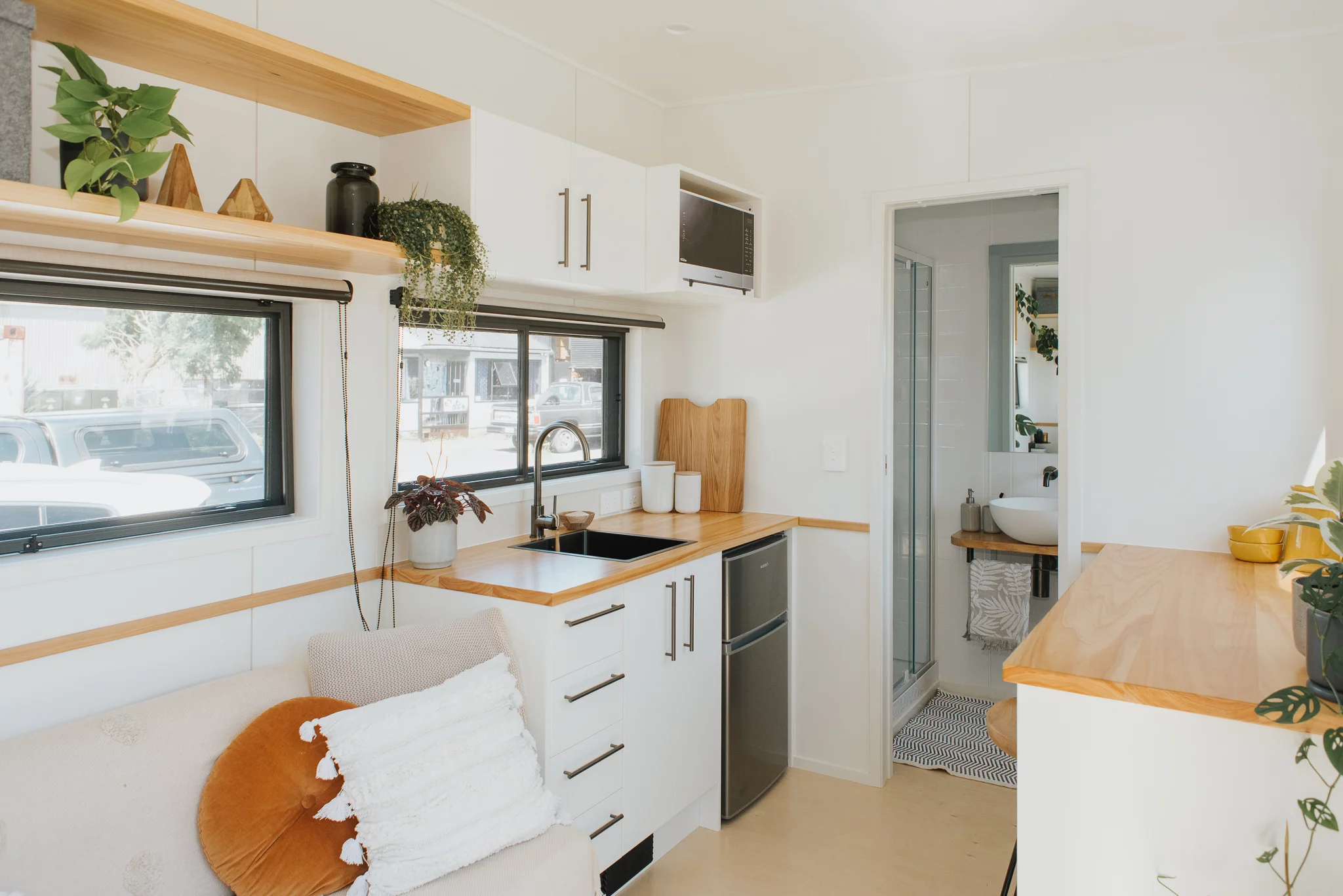The Tadpole Tiny House's kitchen is quite basic and includes a fridge/freezer, sink, and microwave