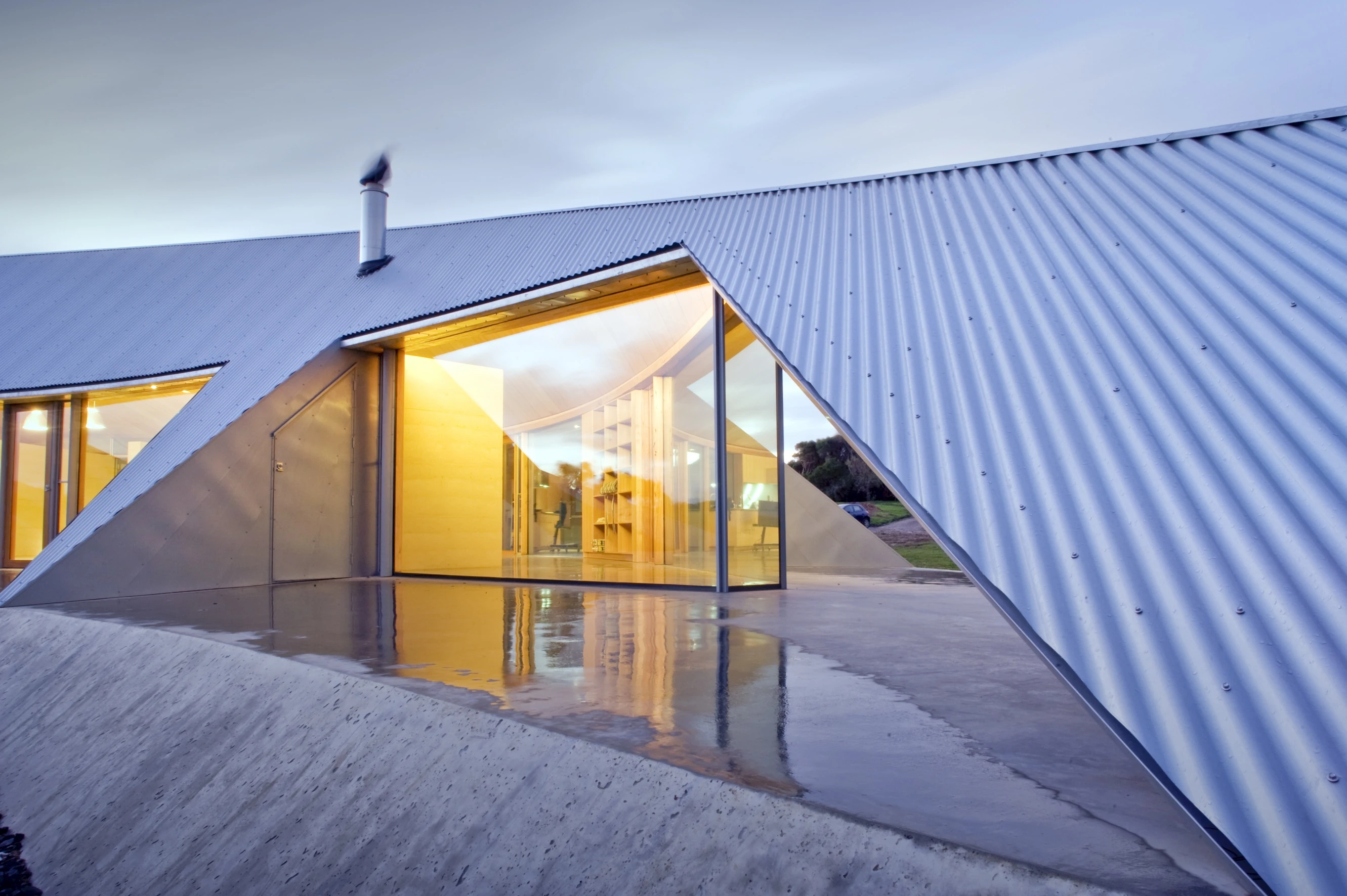 Openings embedded into the corrugated metal siding provide a sheltered outdoor terrace