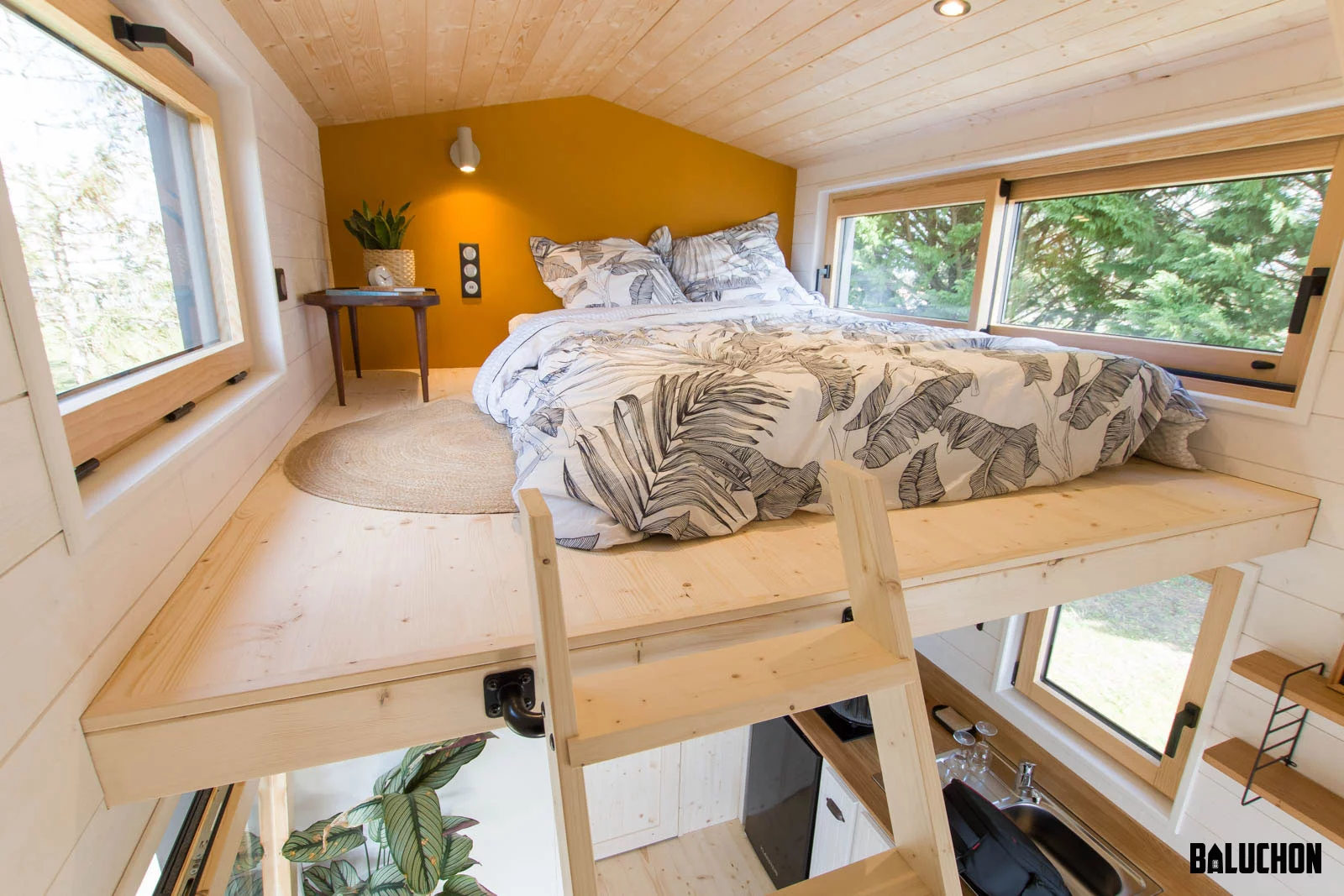 The Miss Twain Tiny House's bedroom is a typical tiny house-style space with a low ceiling