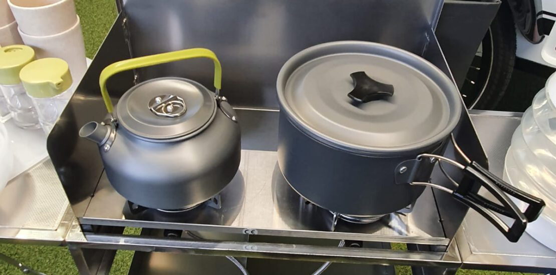 Preparing dinner on the portable kitchen, available optionally for the Mody trailer lineup