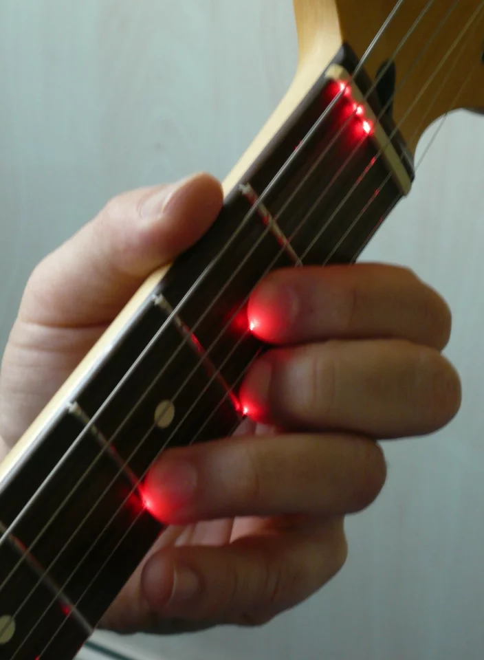 As a player places a finger on the string the beam is shortened and light is reflected back to photo elements at the bridge