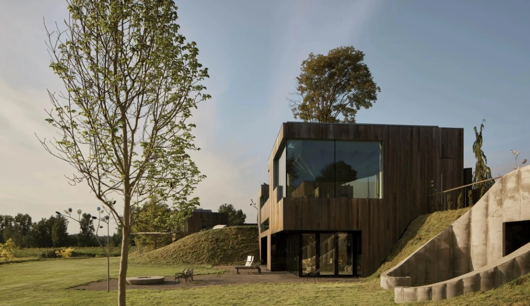 The home is clad in timber paneling and features large windows