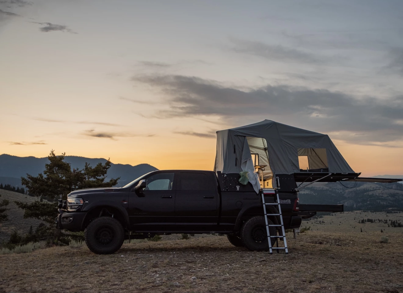The Skinny Guy pickup topper is designed to sleep two and seat up to four inside its tent