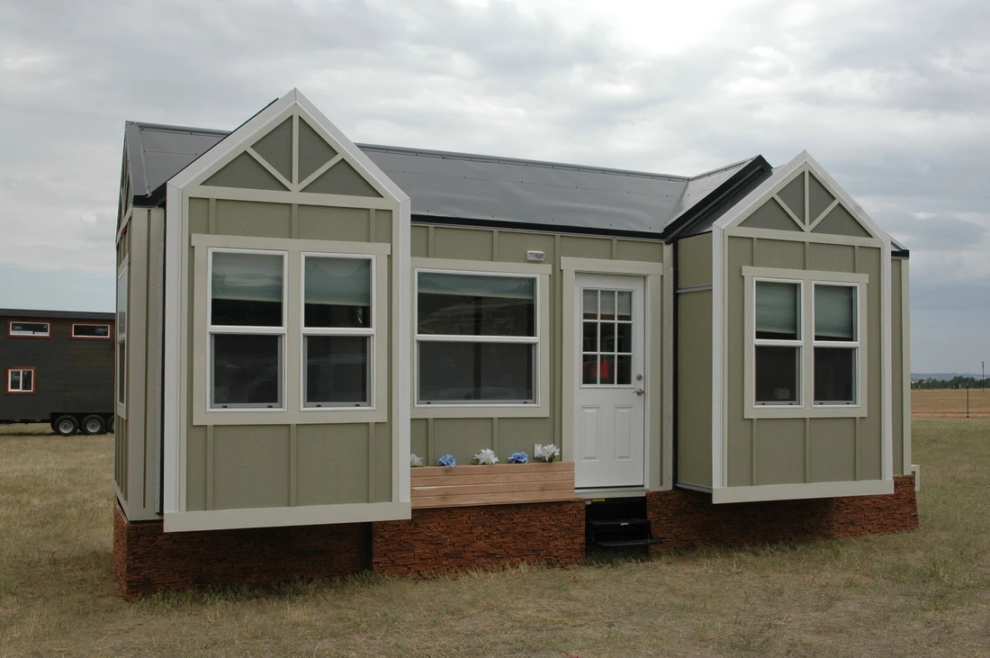 The roof is metal and the siding is board and batten, while the interior is finished in white painted ply