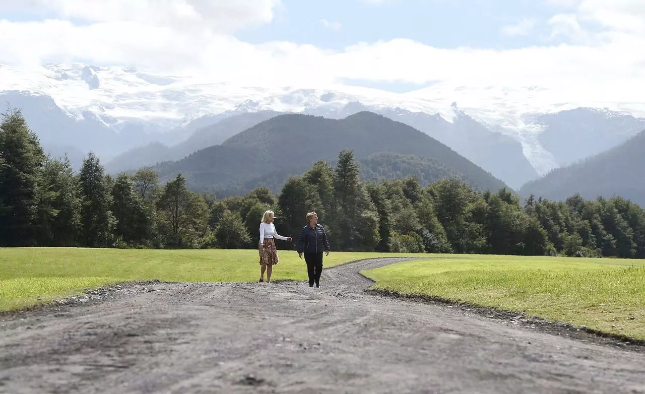 Kris Tompkins walks with Chilean president Michelle Bachelet in Pumalin Park