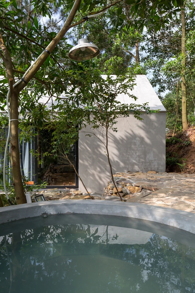 An outdoor tub located amid the lush forest setting next to the home