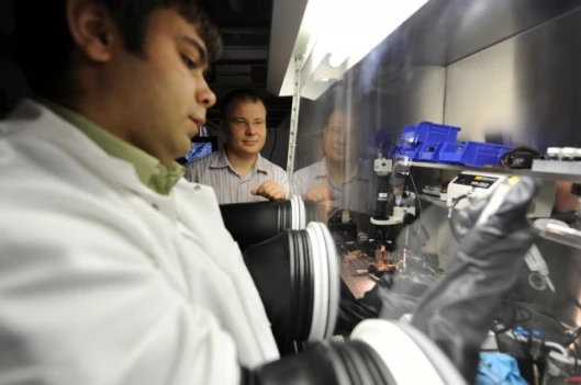 Postdoctoral scholar Maksym Kovalenko (left) works with nanocrystals in a glovebox in the laboratory of Dmitri Talapin, assistant professor in chemistry at the University of Chicago(Photo: Dan Dry)