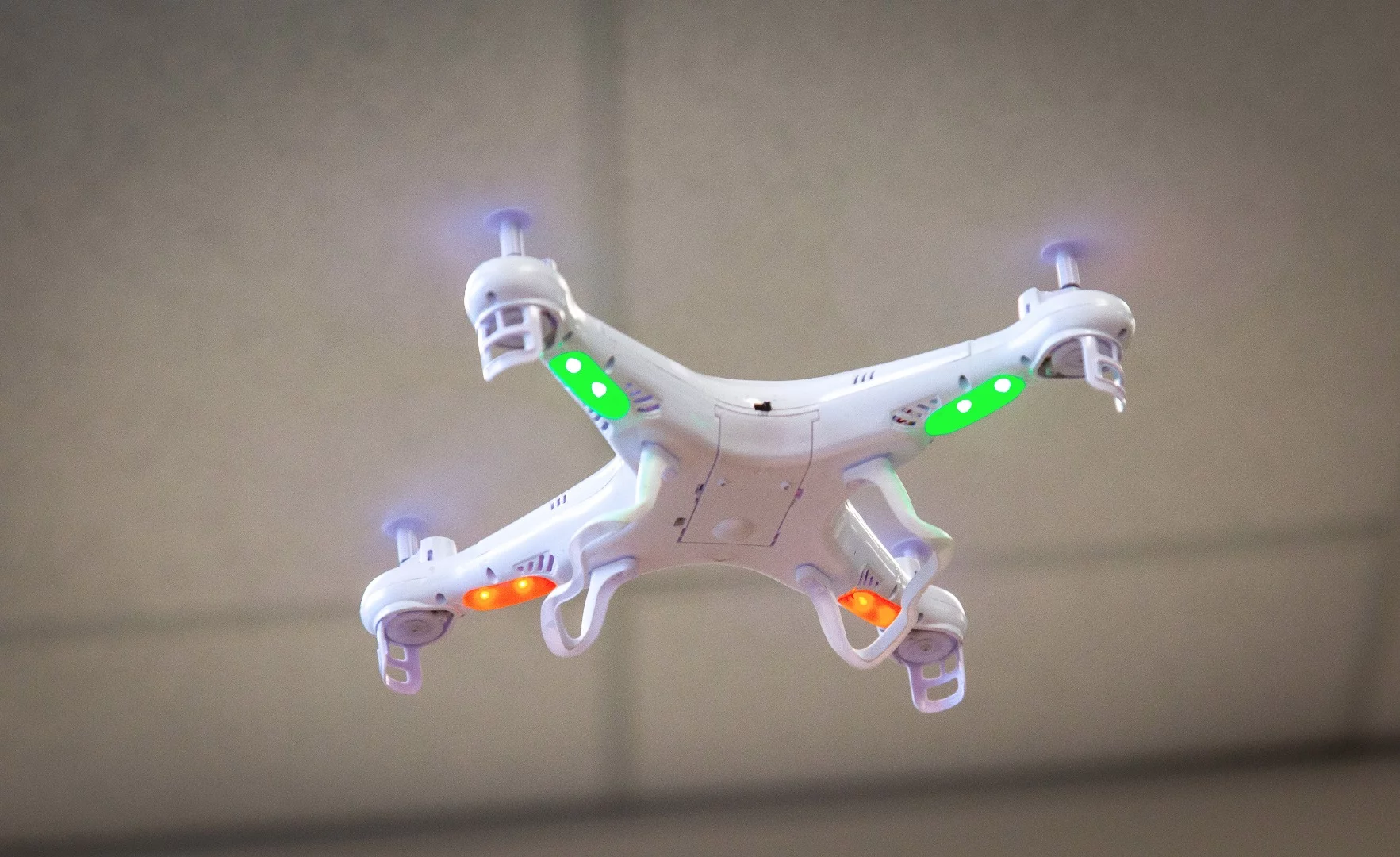 Syma X5 in flight - green lights are the rear lights and orange are the front lights.