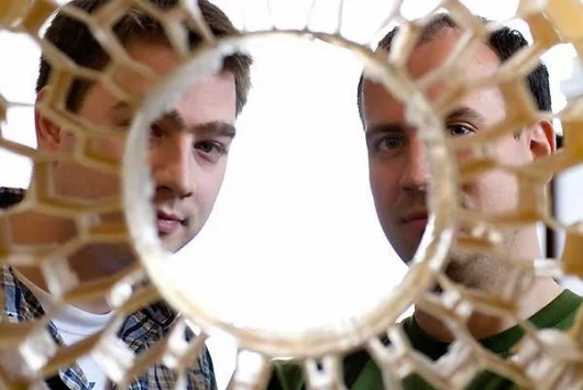 Eric Foltz (left) and Nick Newman look through the honeycomb pattern of an early prototype of a non-pneumatic tire. Foltz, Newman and Osswald (not pictured), worked with Resilient Technologies to design and develop the airless vehicle tire for military us