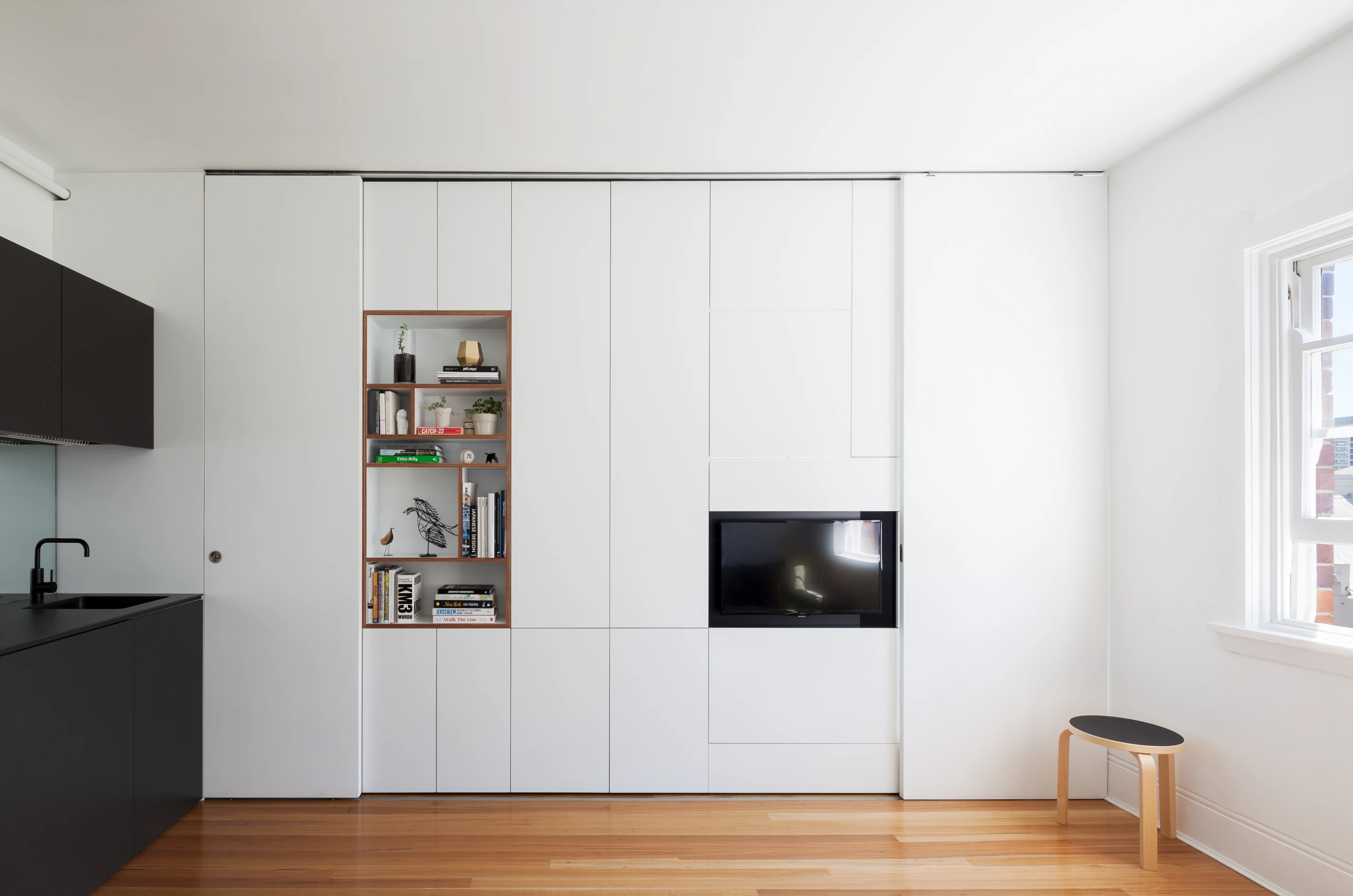 The tiny apartment features a snug double bedroom, open living with European kitchen and laundry
