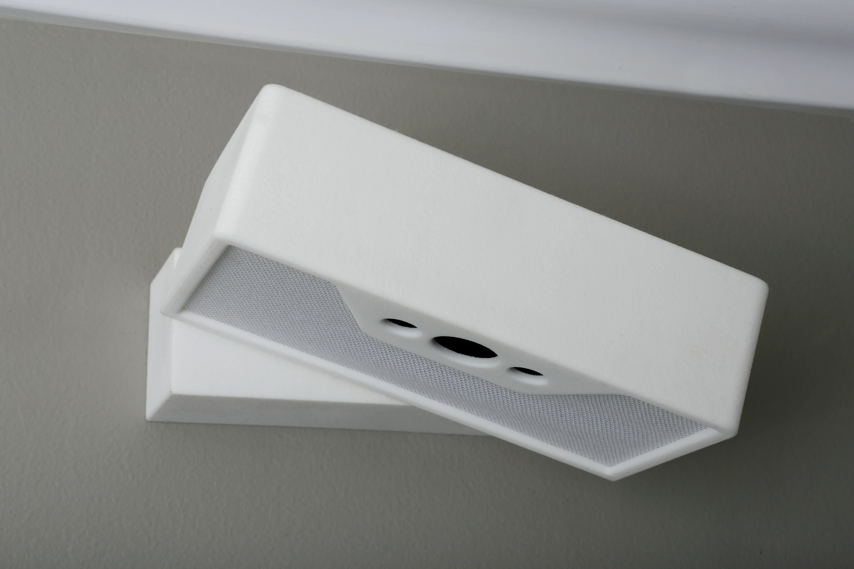 The white-brick-shaped box is attached to a wall mount above the user's bed (Photo: Lucera Labs)