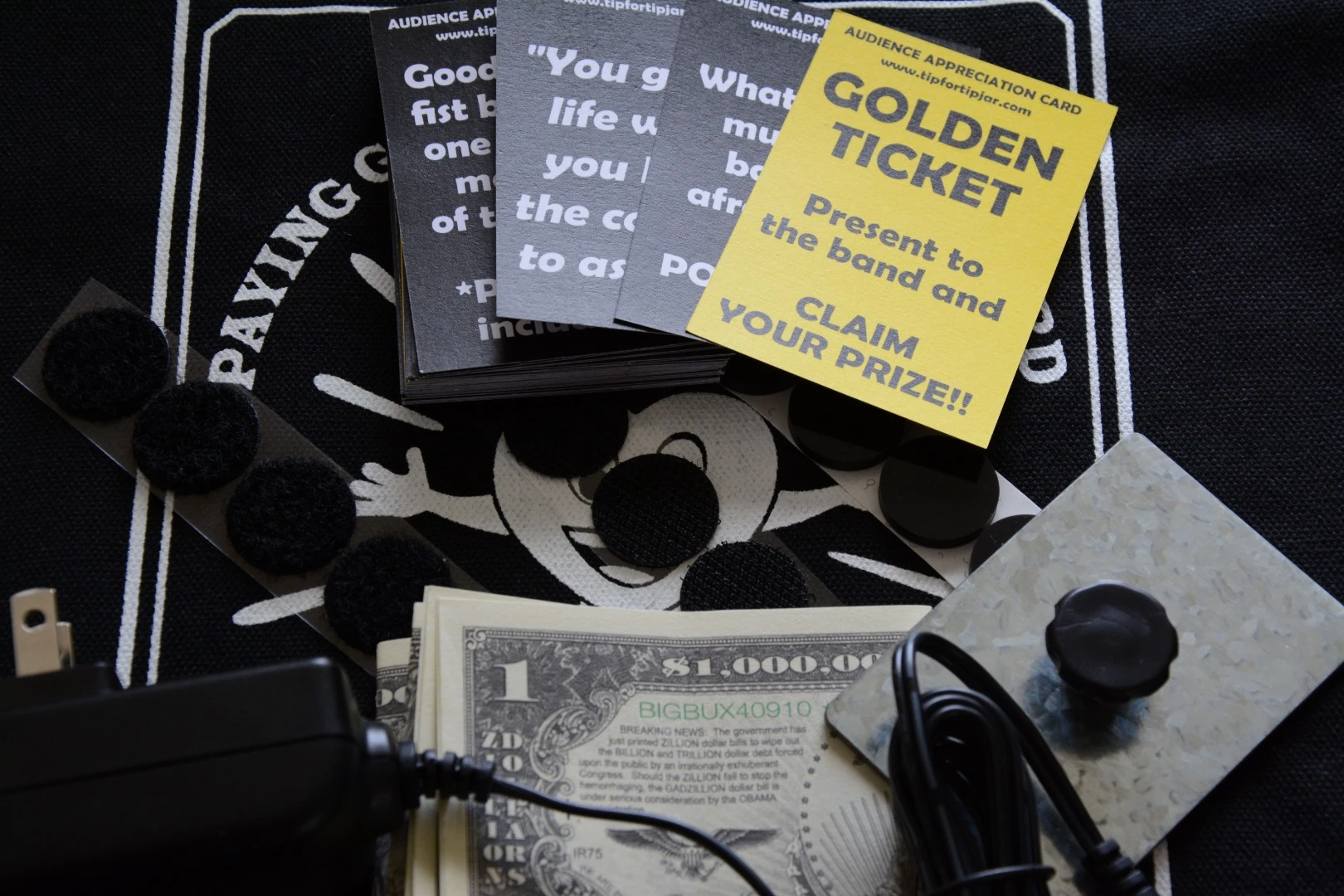 Phil the Tip Jar comes with some adhesive-backed rubber or Velcro feet, a fabric carry bag, some sample cards and a metal block to weigh the cards down when in the magazine