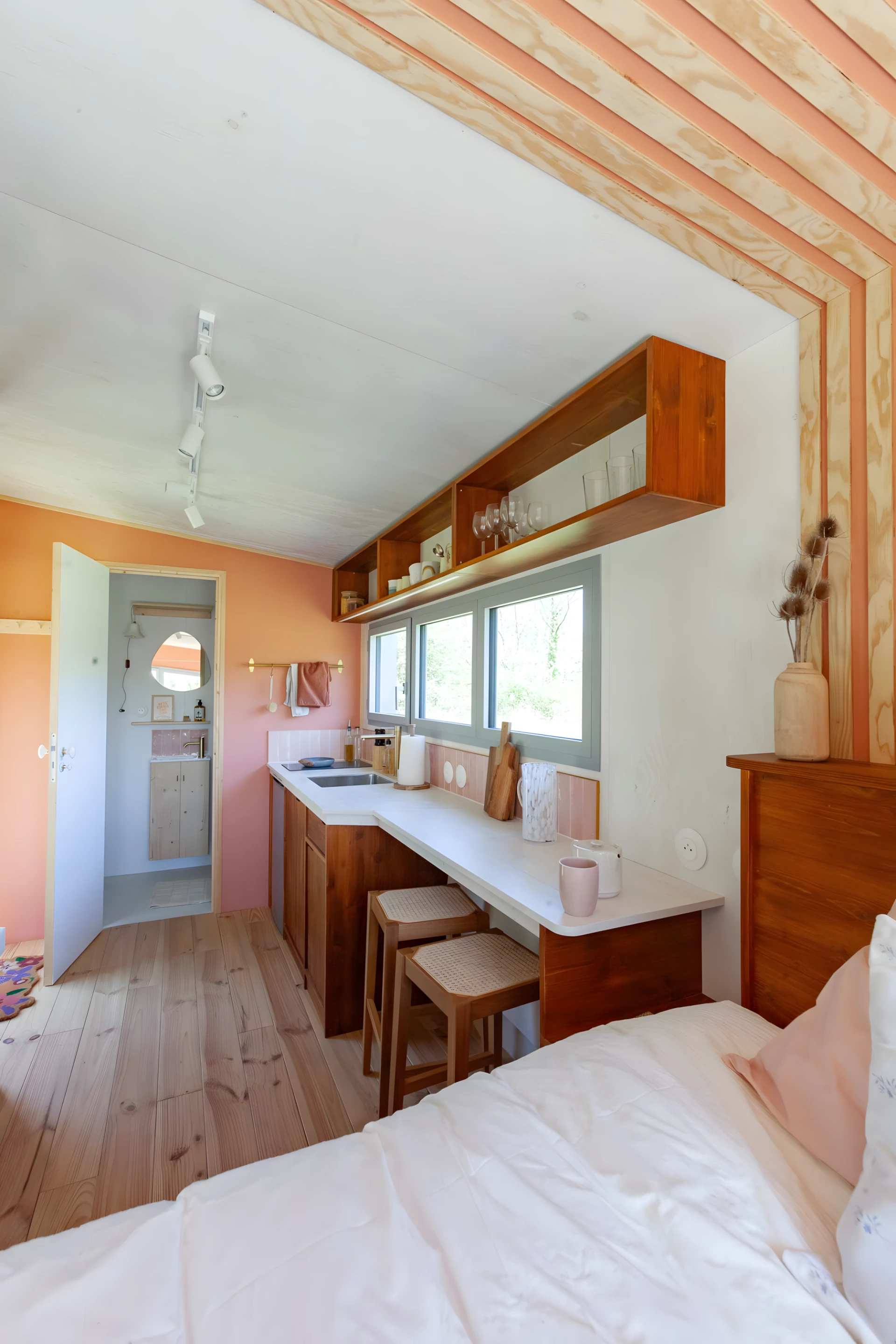The Botanical Cabin's kitchen includes a fridge, an electric cooktop, and a breakfast bar for two