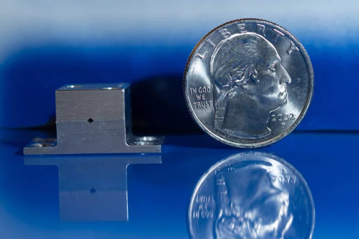 The new quantum cascade laser, which could help astronauts hunt for water on the Moon, next to a US quarter for scale