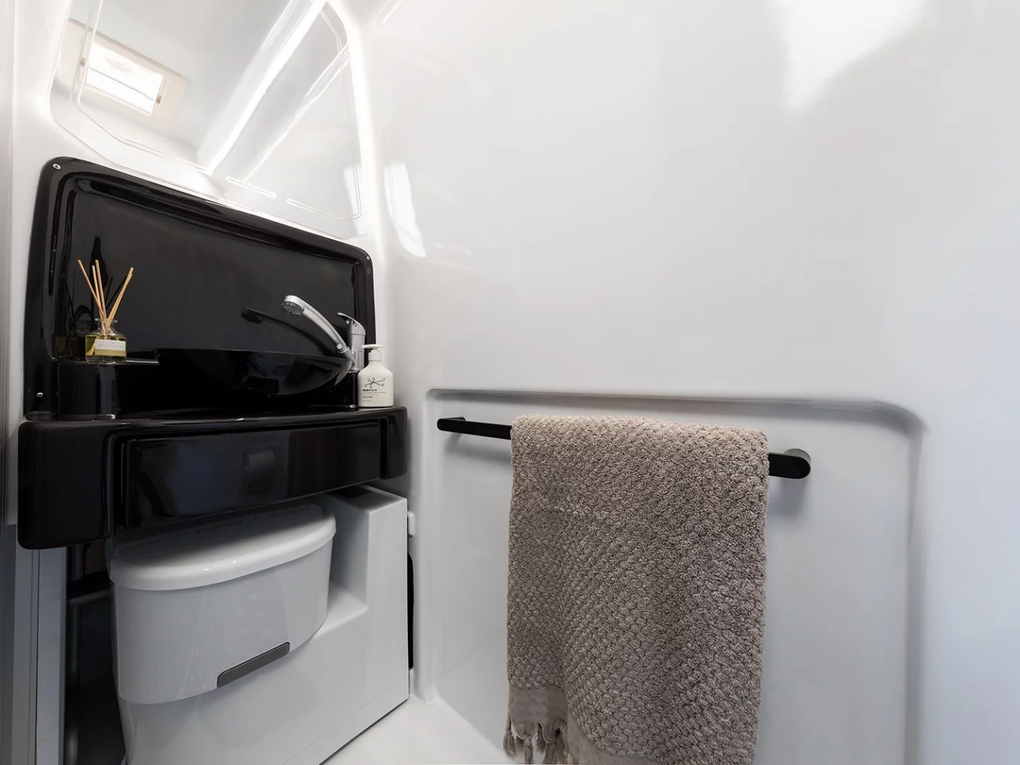 The bathroom features an electric retractable toilet to make more space for showering