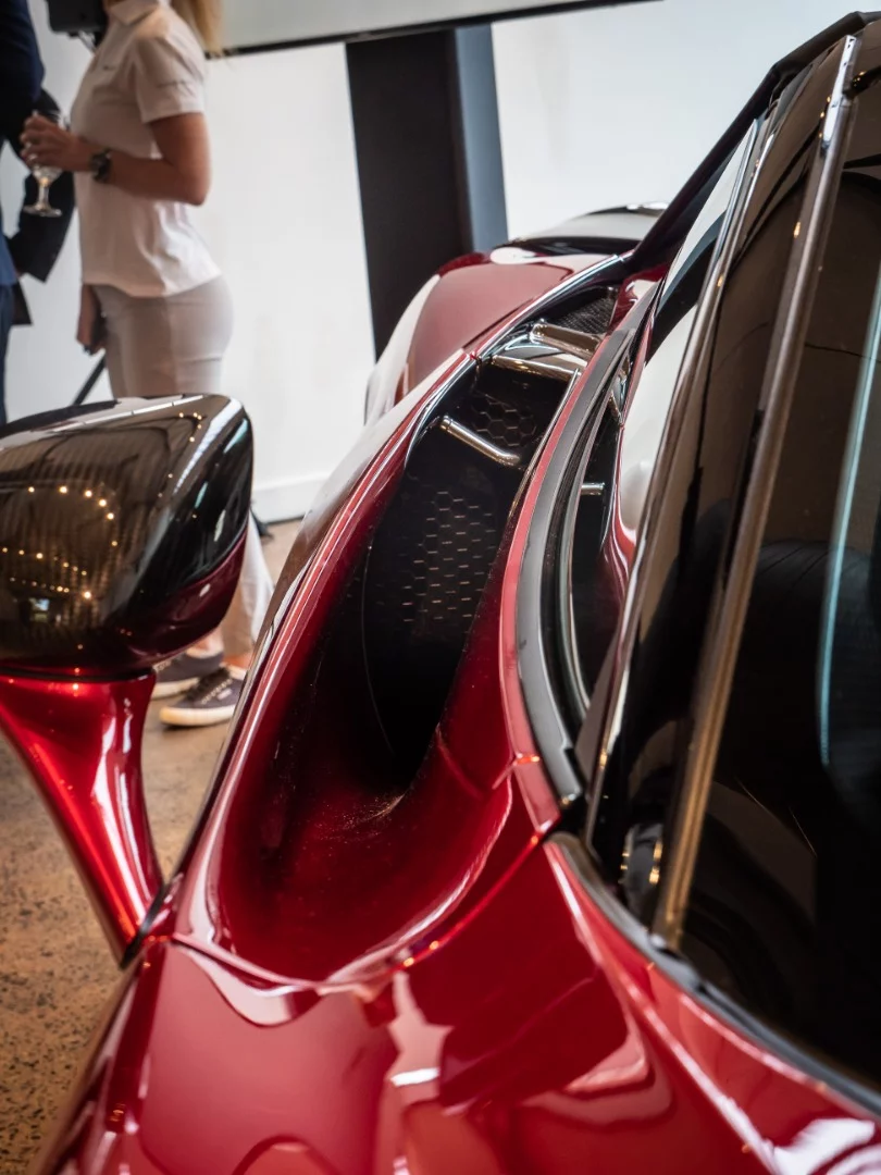 Side vents behind the doors feed the rear-mounted engine